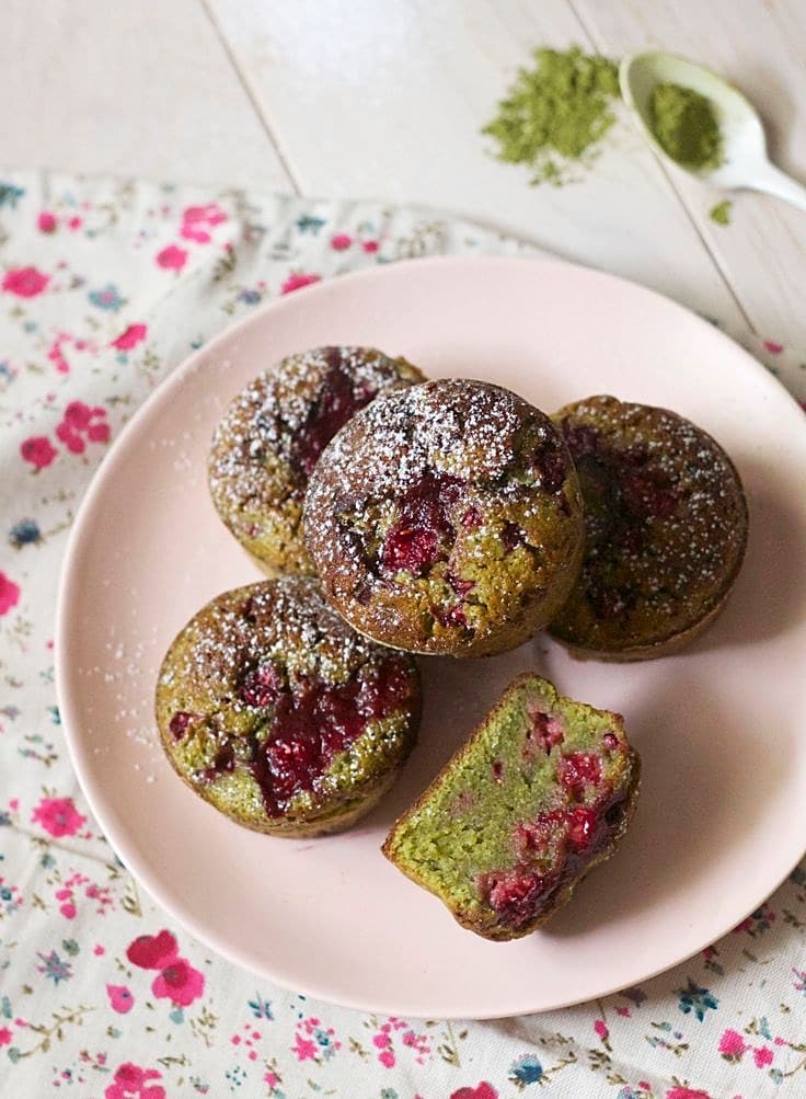 Muffins au matcha et aux framboises saupoudrés de sucre glace sur une assiette rose